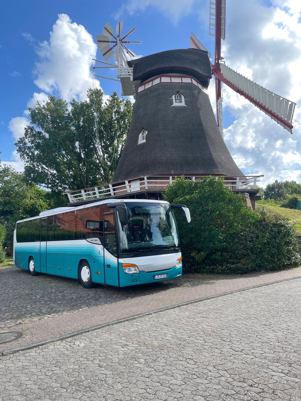 Reisebus von Kleine Busreisen vor einer Windmühle